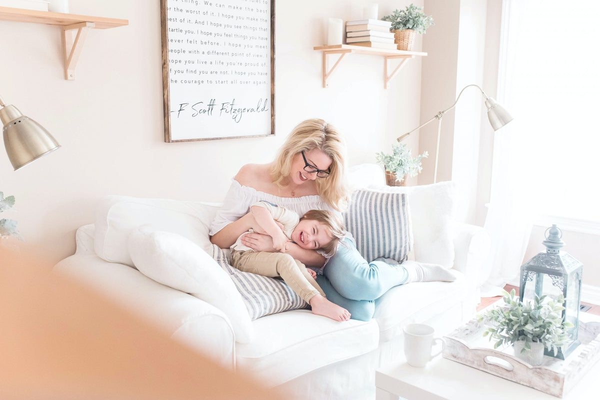 Mother hugging her child on a bright couch celebrating love and connection for Mother’s Day