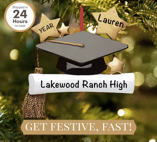 Close-up of a graduation cap ornament hanging on a Christmas tree.