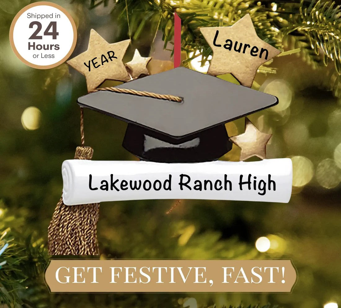 Close-up of a graduation cap ornament hanging on a Christmas tree.