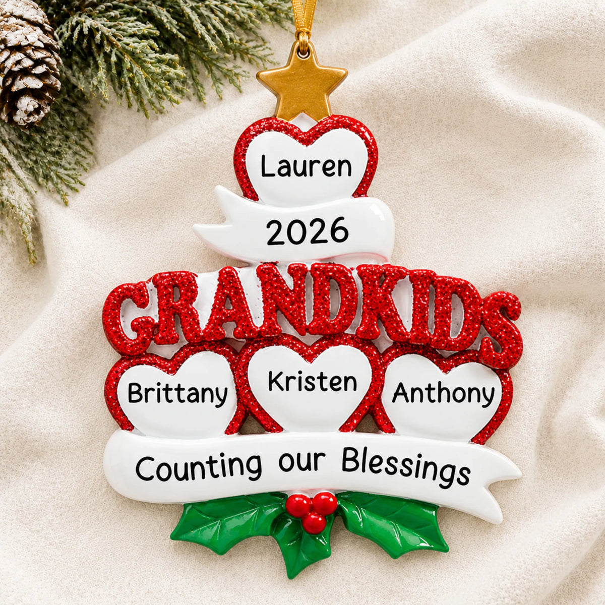 Personalized grandkids 4 hearts christmas ornament laid on a soft white knit blanket