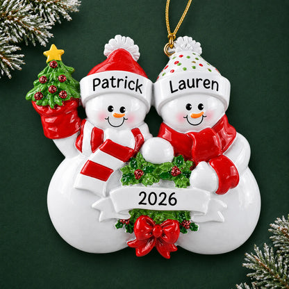 Personalized snowman couple christmas ornament on a dark green pine background