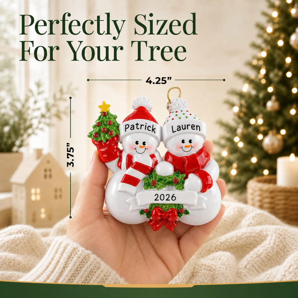 Size guide: the personalized snowman couple christmas ornament is 4.25 in wide by 3.75 in tall, shown in hand