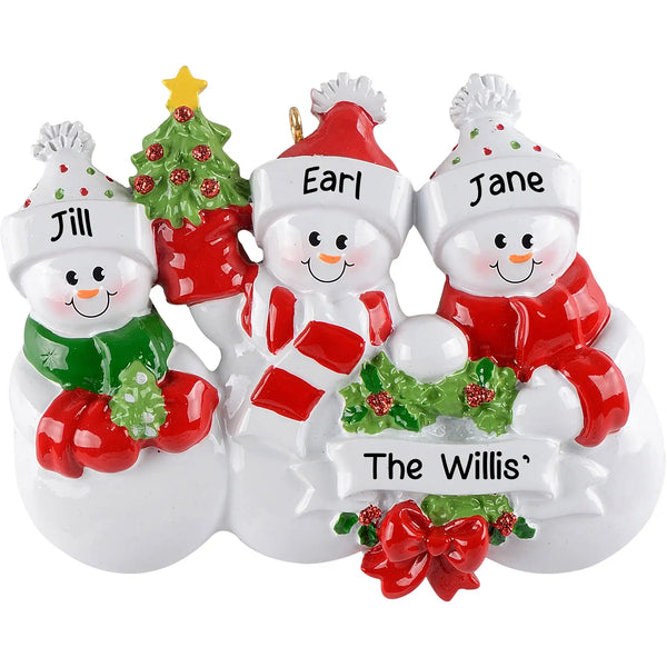 Personalized Christmas ornament featuring three snowman figures in winter gear, holding a central blank white banner ready for custom name engraving.