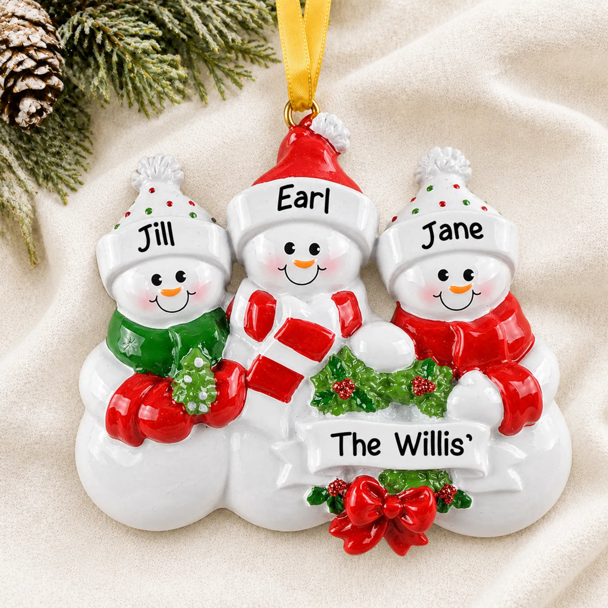 Personalized snowman family of 3 christmas ornament laid on a soft white knit blanket