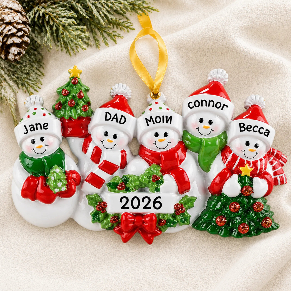 Personalized snowman family of 5 christmas ornament laid on a soft white knit blanket