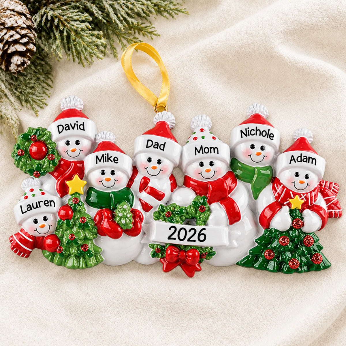 Personalized snowman family of 7 christmas ornament laid on a soft white knit blanket