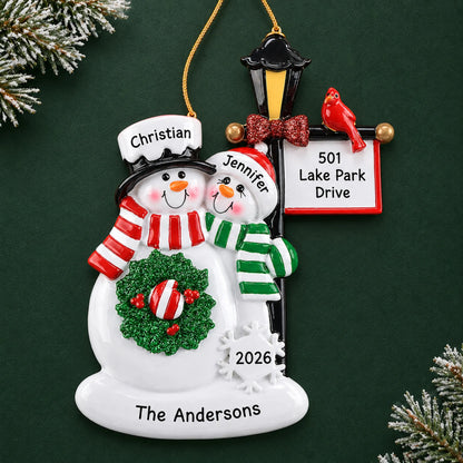 Personalized snowman couple lamppost christmas ornament on a dark green pine background