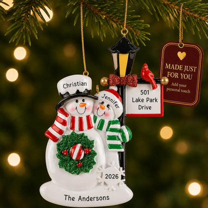 Snowman couple lamppost christmas ornament hanging on a lit Christmas tree with a Made Just For You gift tag