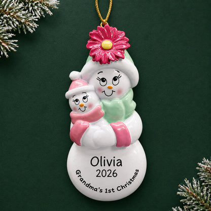 Personalized pink grandma's 1st christmas ornament on a dark green pine background