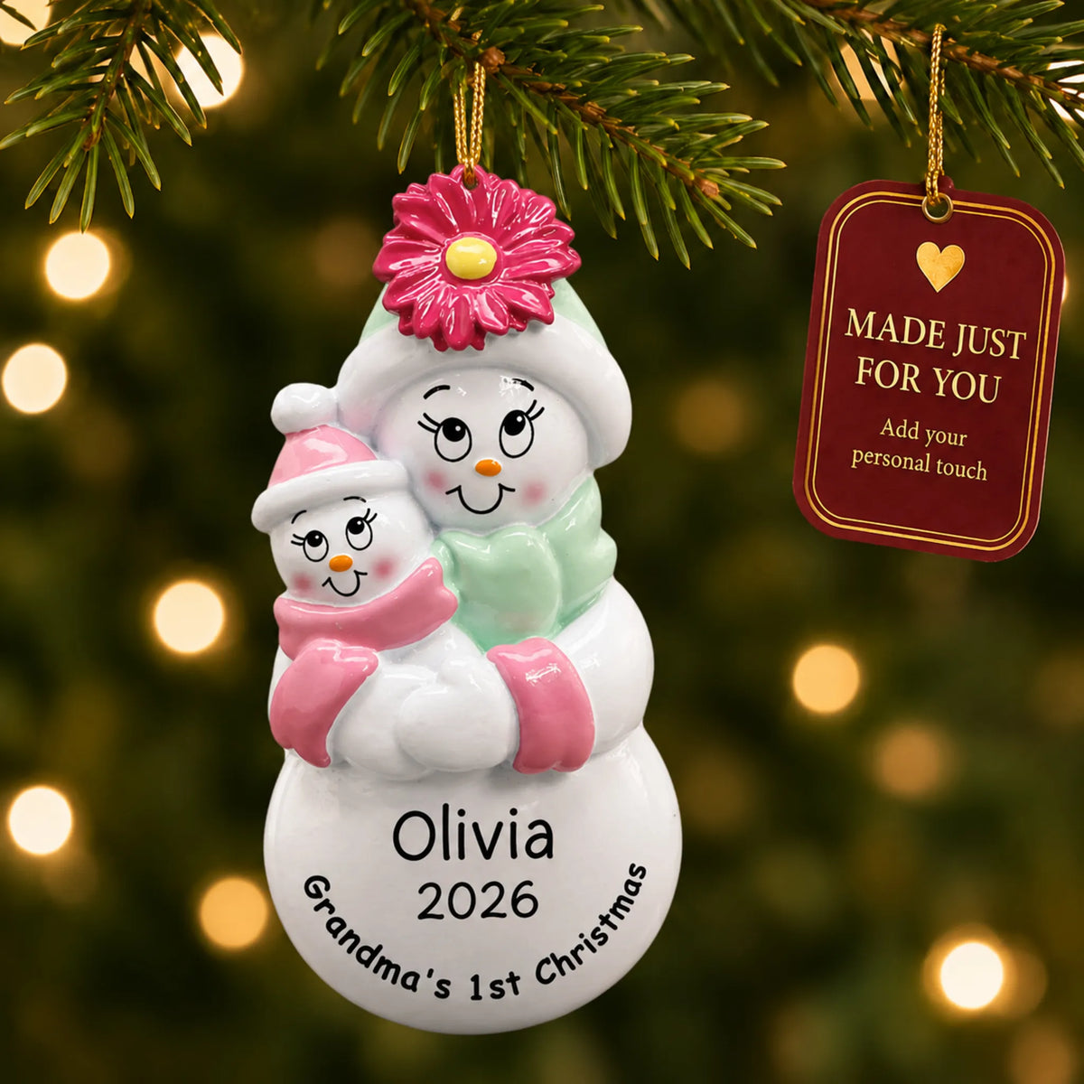 Pink grandma's 1st christmas ornament hanging on a lit Christmas tree with a Made Just For You gift tag