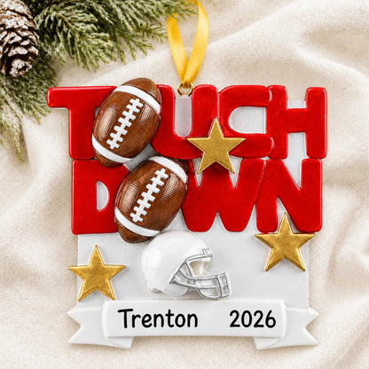 Personalized football touchdown christmas ornament laid on a soft white knit blanket
