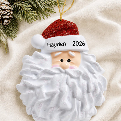 Personalized Santa Glitter Beard christmas ornament laid on a soft white knit blanket
