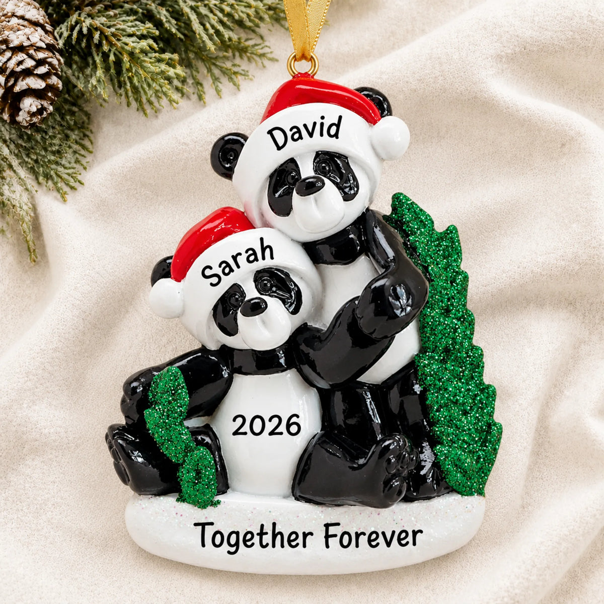 Personalized panda couple christmas ornament laid on a soft white knit blanket