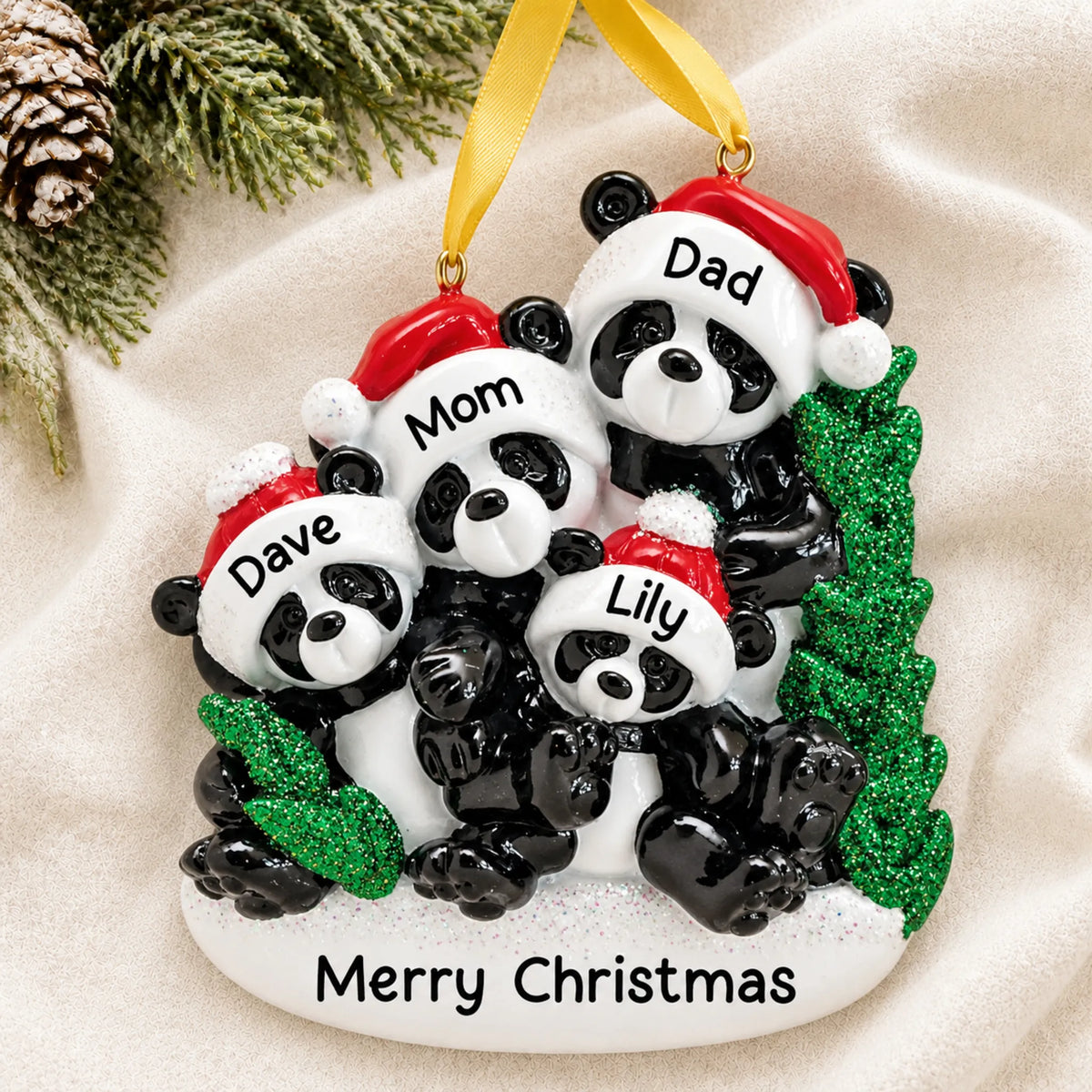 Personalized panda family of 4 christmas ornament laid on a soft white knit blanket