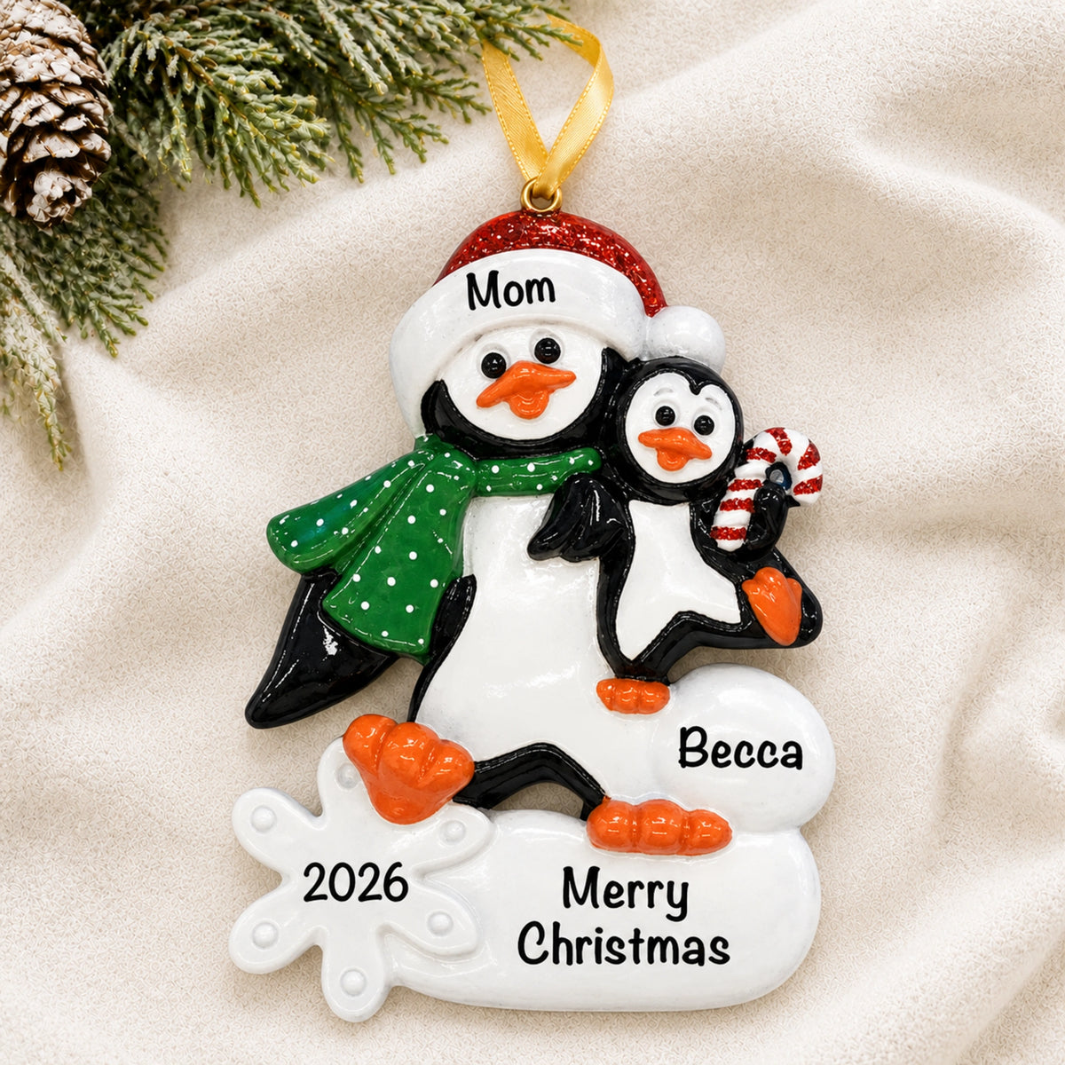 Personalized single parent penguin with child christmas ornament with names on a soft blanket