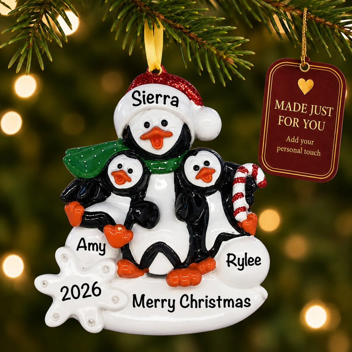 Single parent penguin with 2 kids christmas ornament hanging on a lit Christmas tree with a Made Just For You gift tag