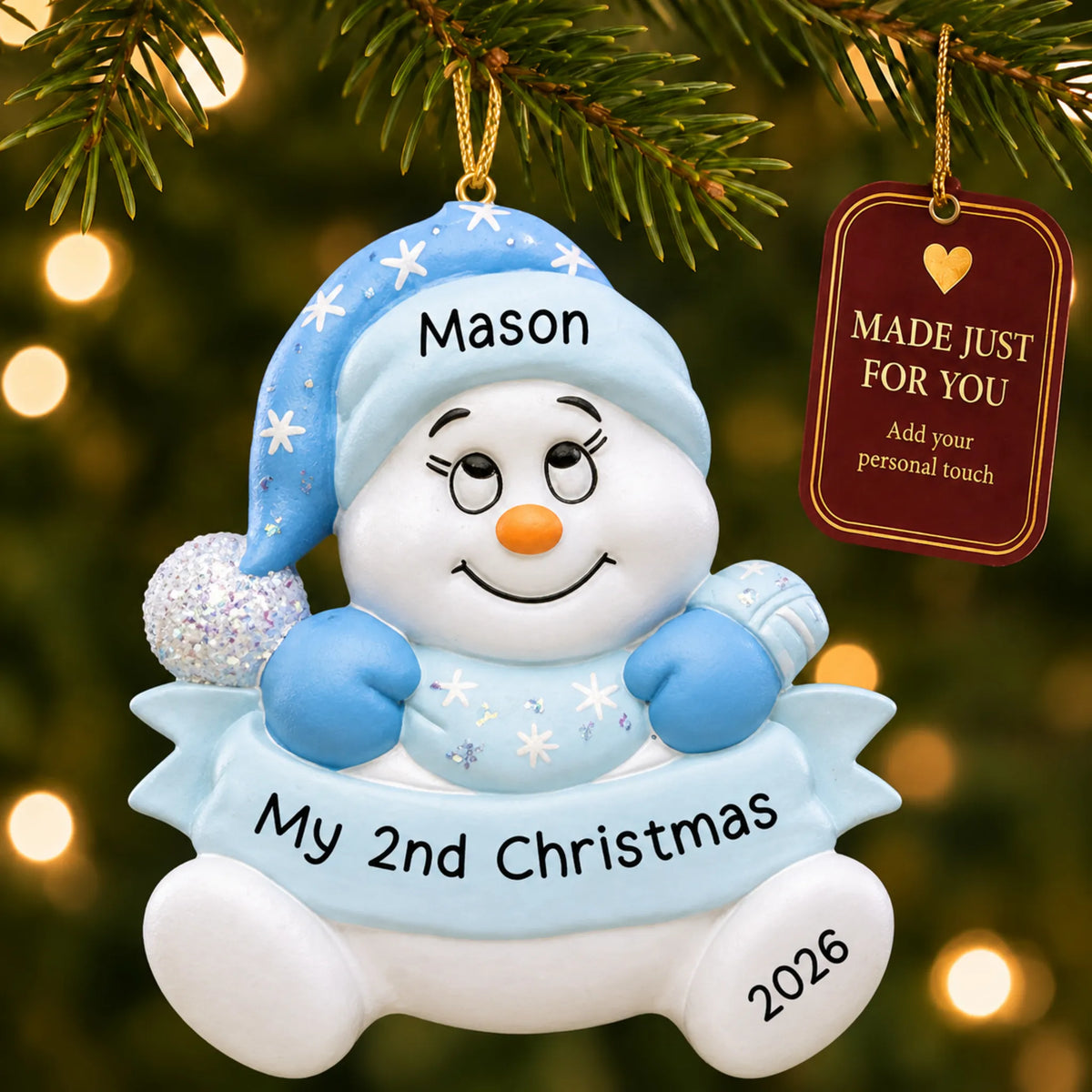 Baby boy 2nd christmas snowman ornament hanging on a lit Christmas tree with a Made Just For You gift tag