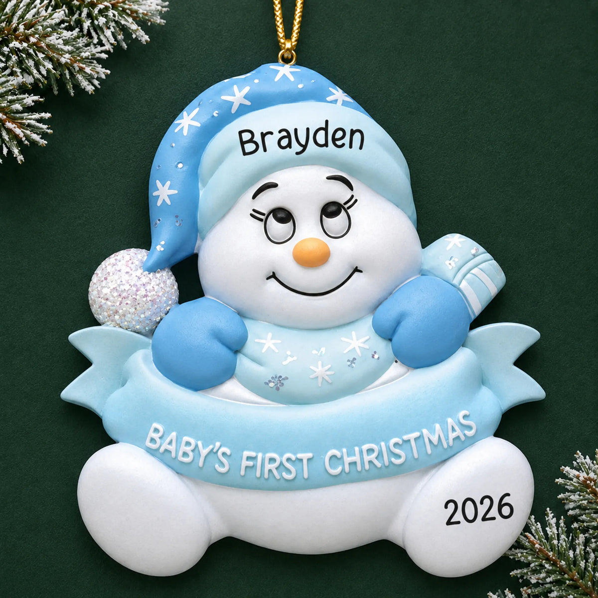 Personalized blue baby's 1st christmas snow baby ornament on a dark green pine background