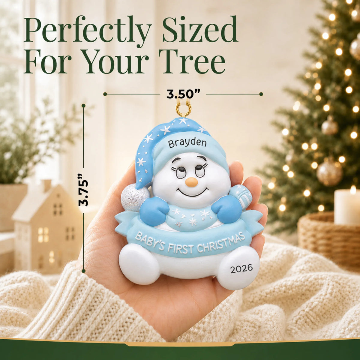 Size guide: the personalized blue baby's 1st christmas snow baby ornament is 3.50 in wide by 3.75 in tall, shown in hand