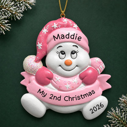 Personalized baby girl 2nd christmas snowman ornament on a dark green pine background
