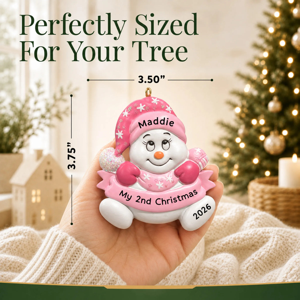 Size guide: the personalized baby girl 2nd christmas snowman ornament shown in hand next to a Christmas tree