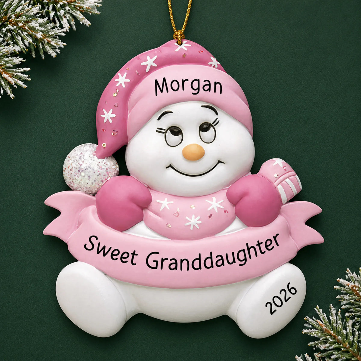 Personalized granddaughter pink snowman christmas ornament on a dark green pine background