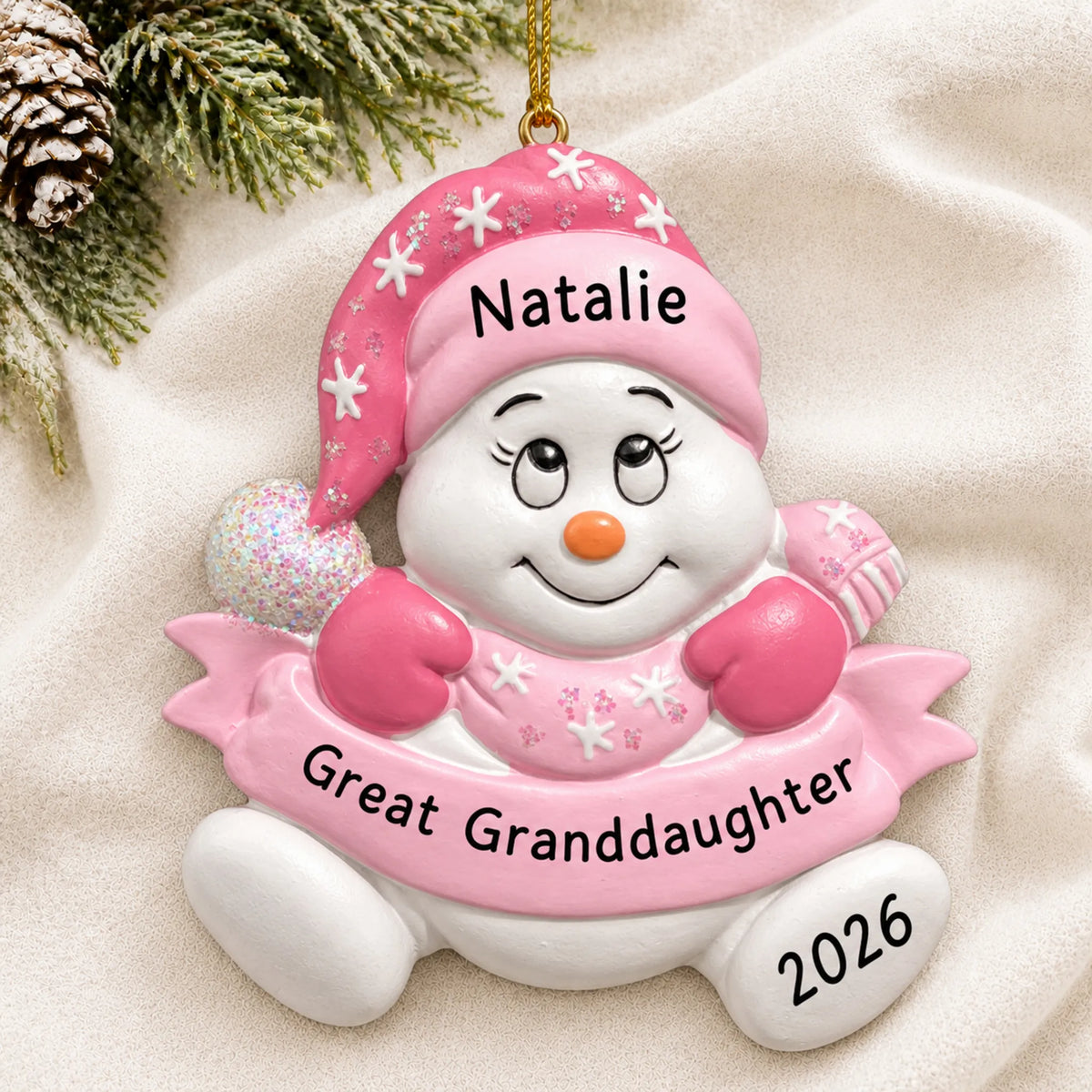 Personalized great granddaughter snowman christmas ornament laid on a soft white knit blanket