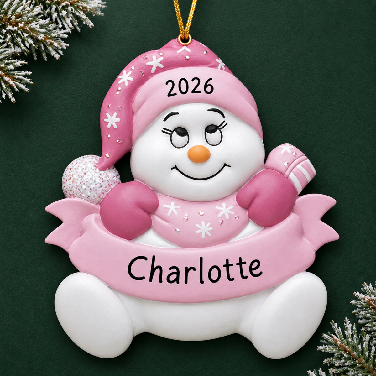 Personalized baby girl pink snowbaby christmas ornament on a dark green pine background