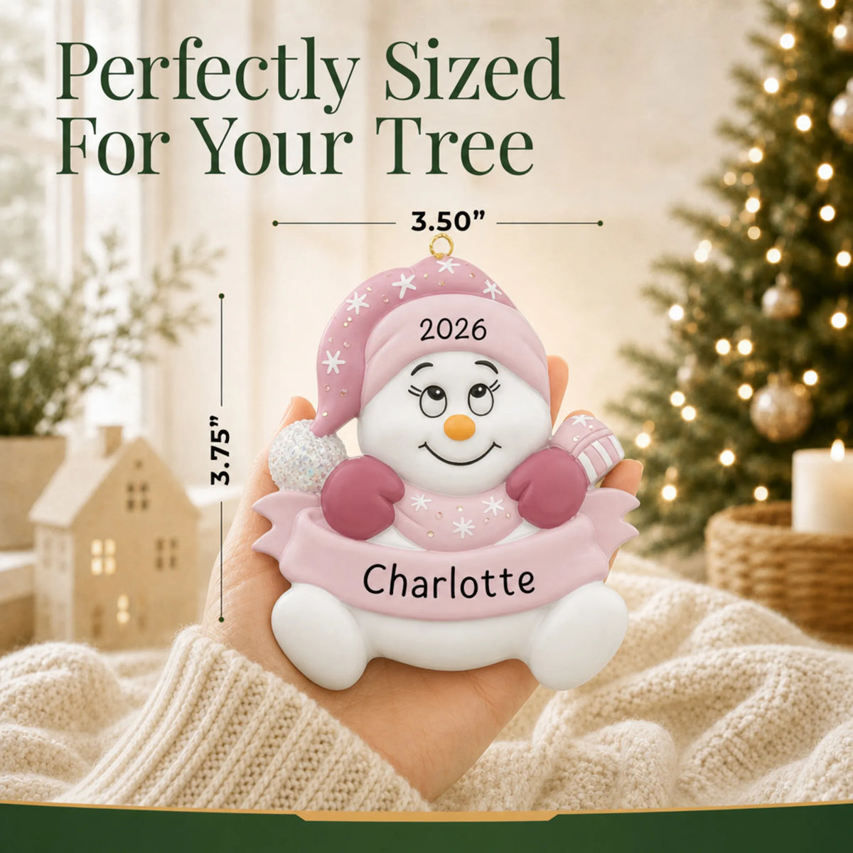 Size guide: the personalized baby girl pink snowbaby christmas ornament is 3.50 in wide by 3.75 in tall, shown in hand