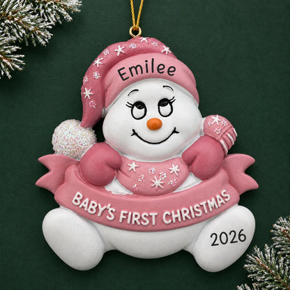 Personalized pink baby's 1st christmas snow baby ornament on a dark green pine background