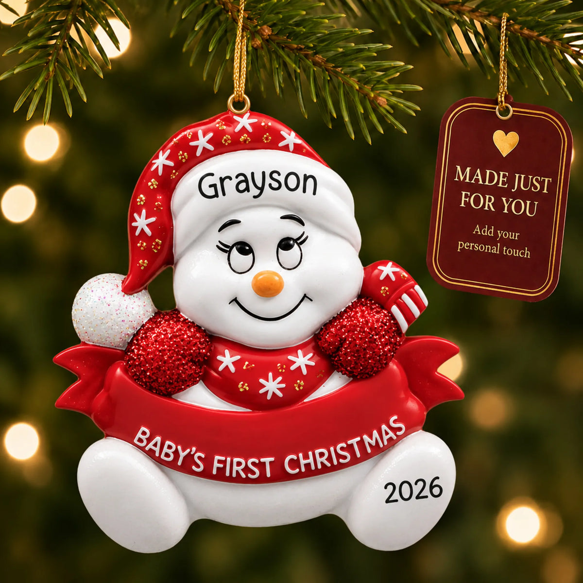Red baby's 1st christmas snowman ornament hanging on a lit Christmas tree with a Made Just For You gift tag