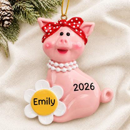 Personalized little piggy christmas ornament laid on a soft white knit blanket