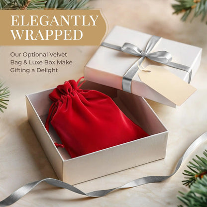 Open gift box with red velvet bag and silver ribbon, surrounded by Christmas tree branches.