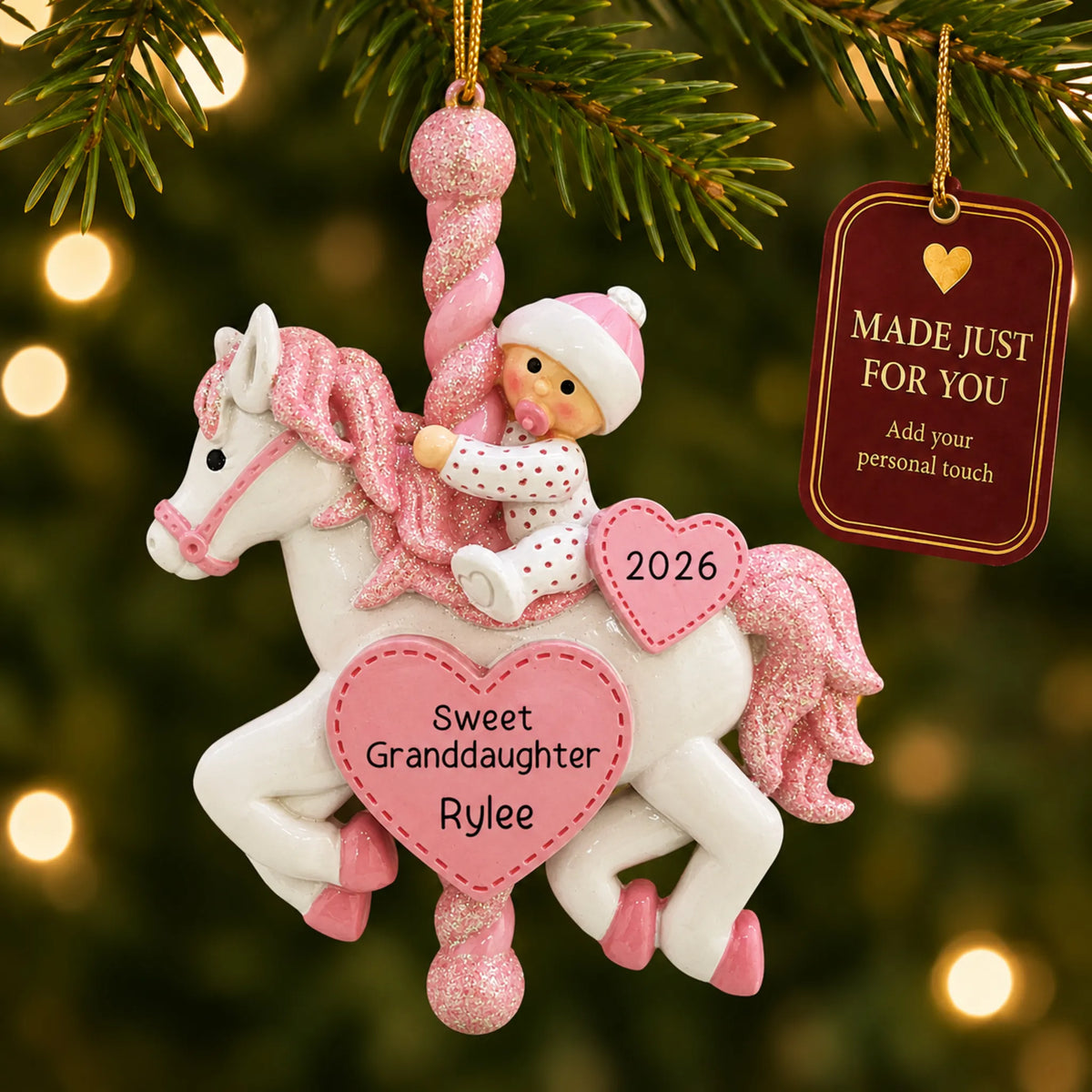 Granddaughter pink baby carousel christmas ornament hanging on a lit Christmas tree with a Made Just For You gift tag