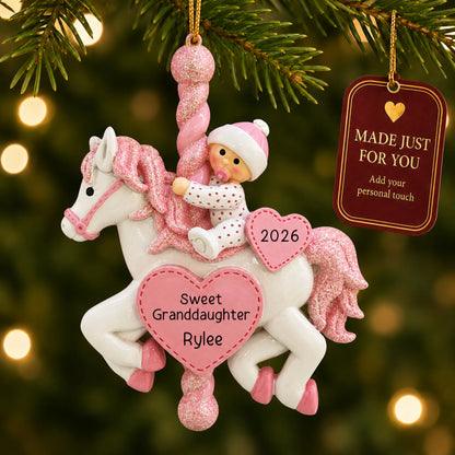 Granddaughter pink baby carousel christmas ornament hanging on a lit Christmas tree with a Made Just For You gift tag