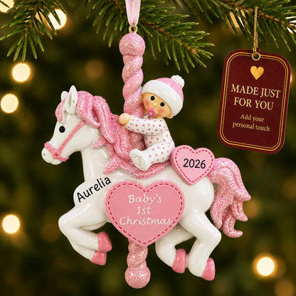 Pink baby's 1st christmas carousel ornament hanging on a lit Christmas tree with a Made Just For You gift tag