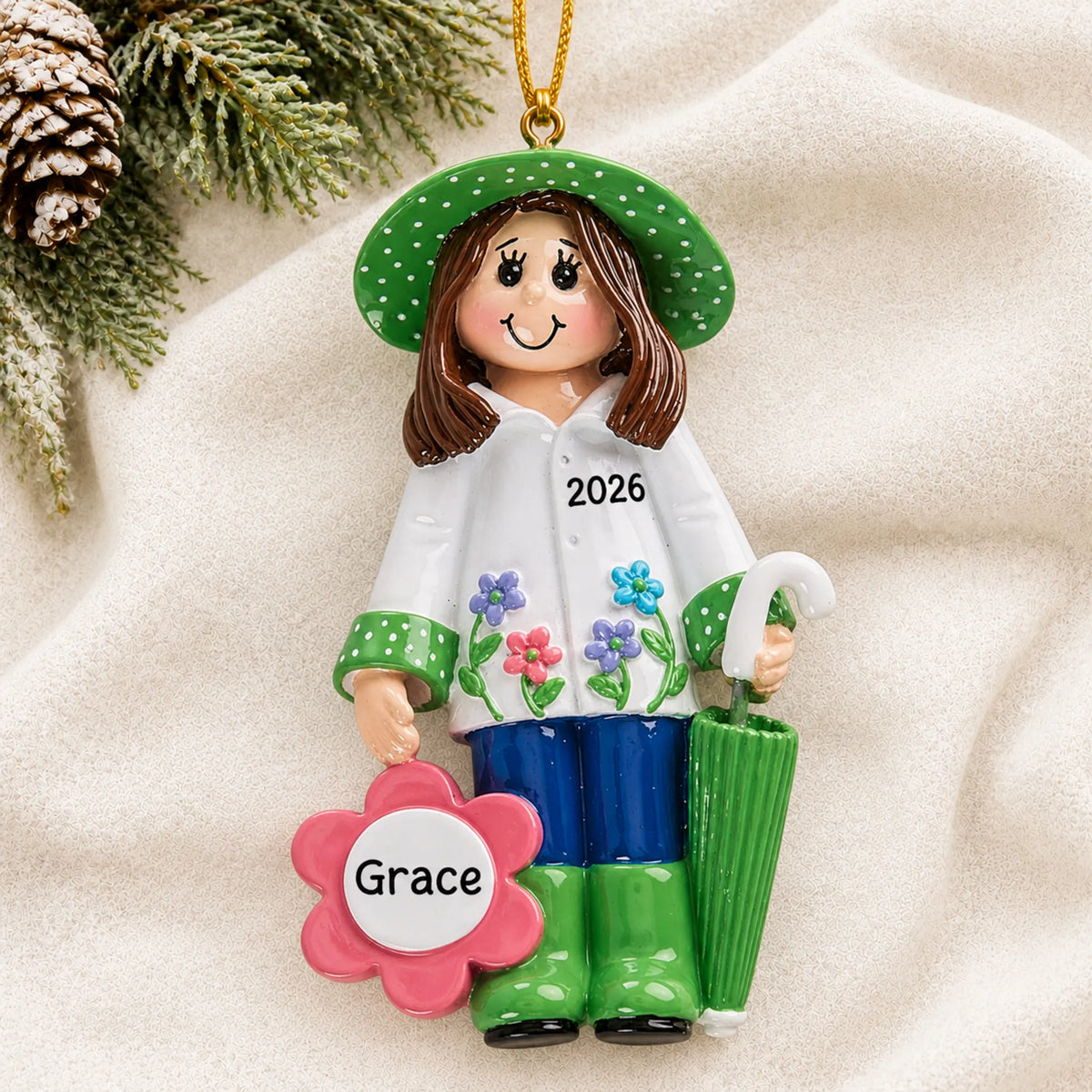 Personalized gardening christmas ornament laid on a soft white knit blanket