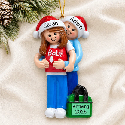 Brunette pregnancy Christmas ornament of an expecting couple resting on a white knit blanket