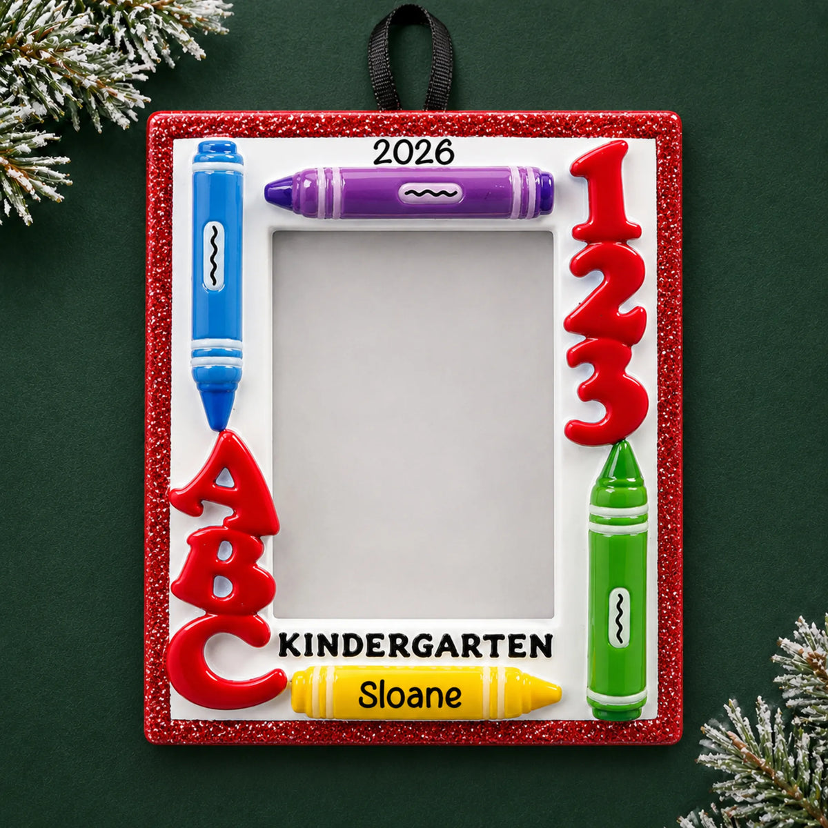 Personalized kindergarten photo frame Christmas ornament with name and year, shown on a green holiday background