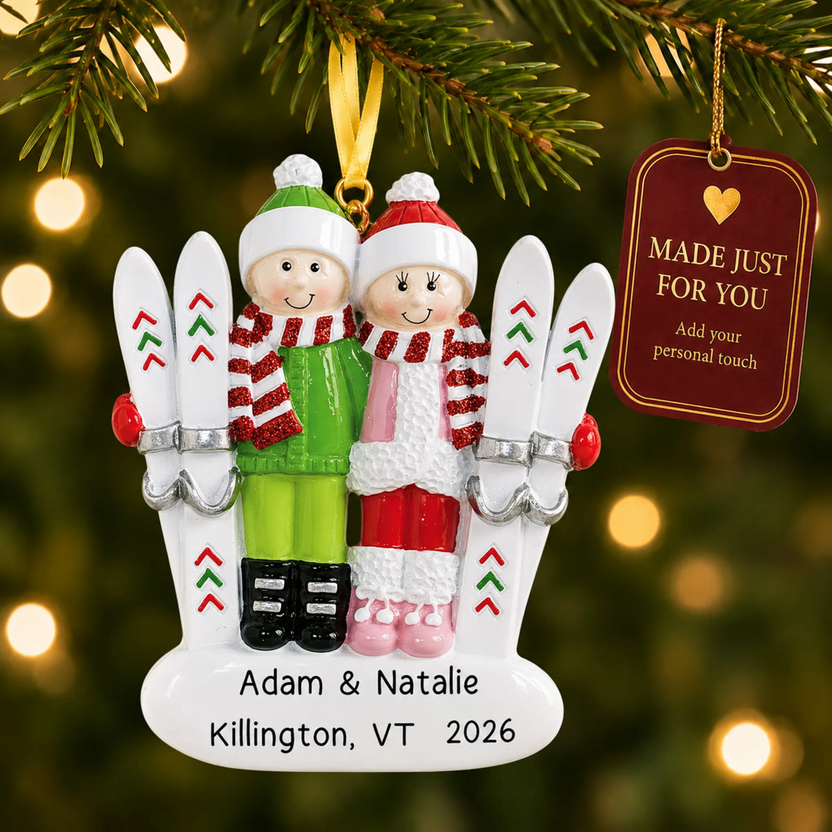 Ski couple christmas ornament hanging on a lit Christmas tree with a Made Just For You gift tag
