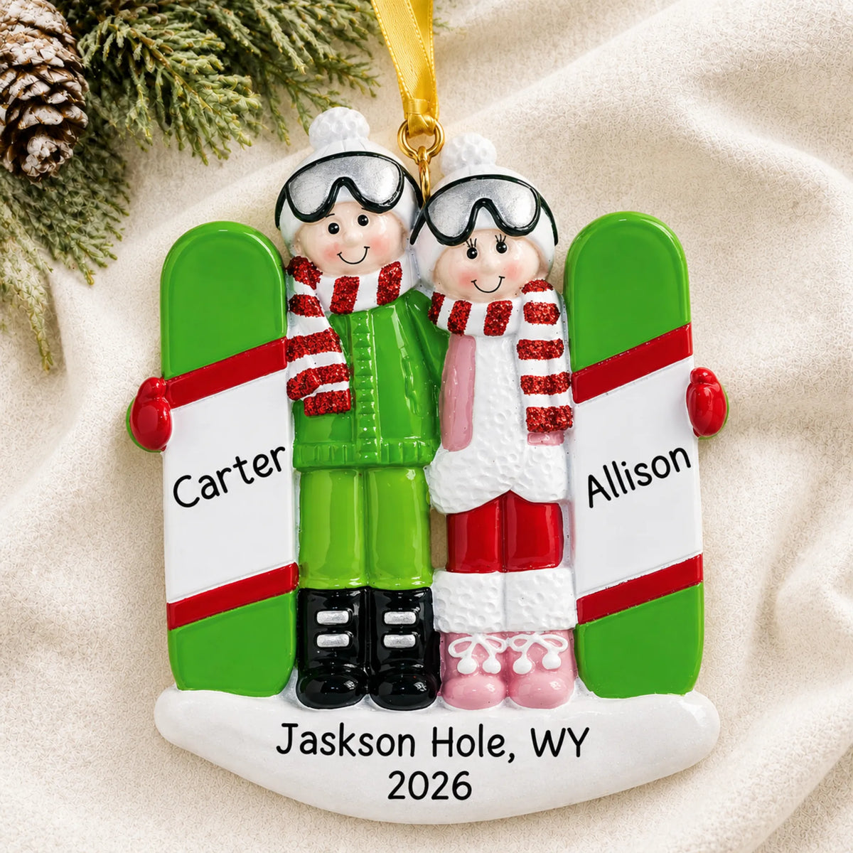Personalized snowboard couple christmas ornament laid on a soft white knit blanket