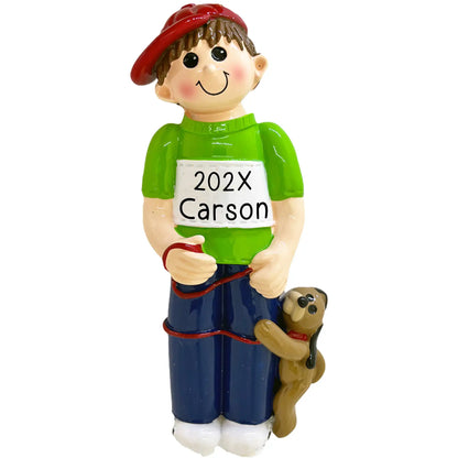 Personalized boy with dog Christmas ornament featuring a smiling boy in a green sweater and red cap with his puppy, customized with name and year