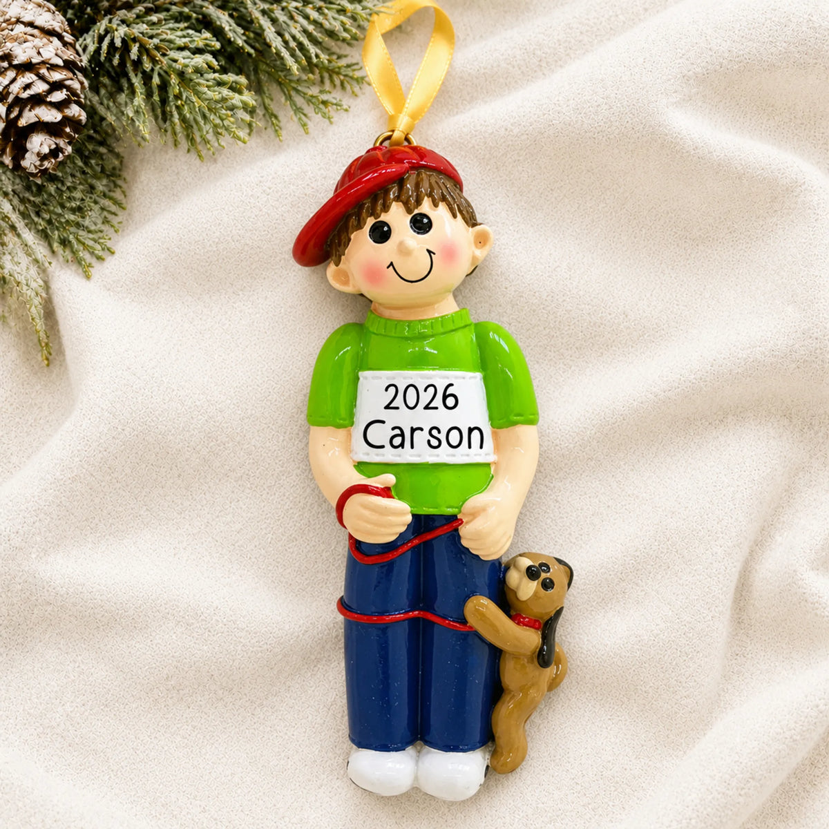 Personalized Boy With Dog christmas ornament laid on a soft white knit blanket