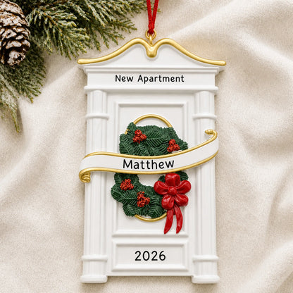 Personalized New or First Apartment christmas ornament laid on a soft white knit blanket