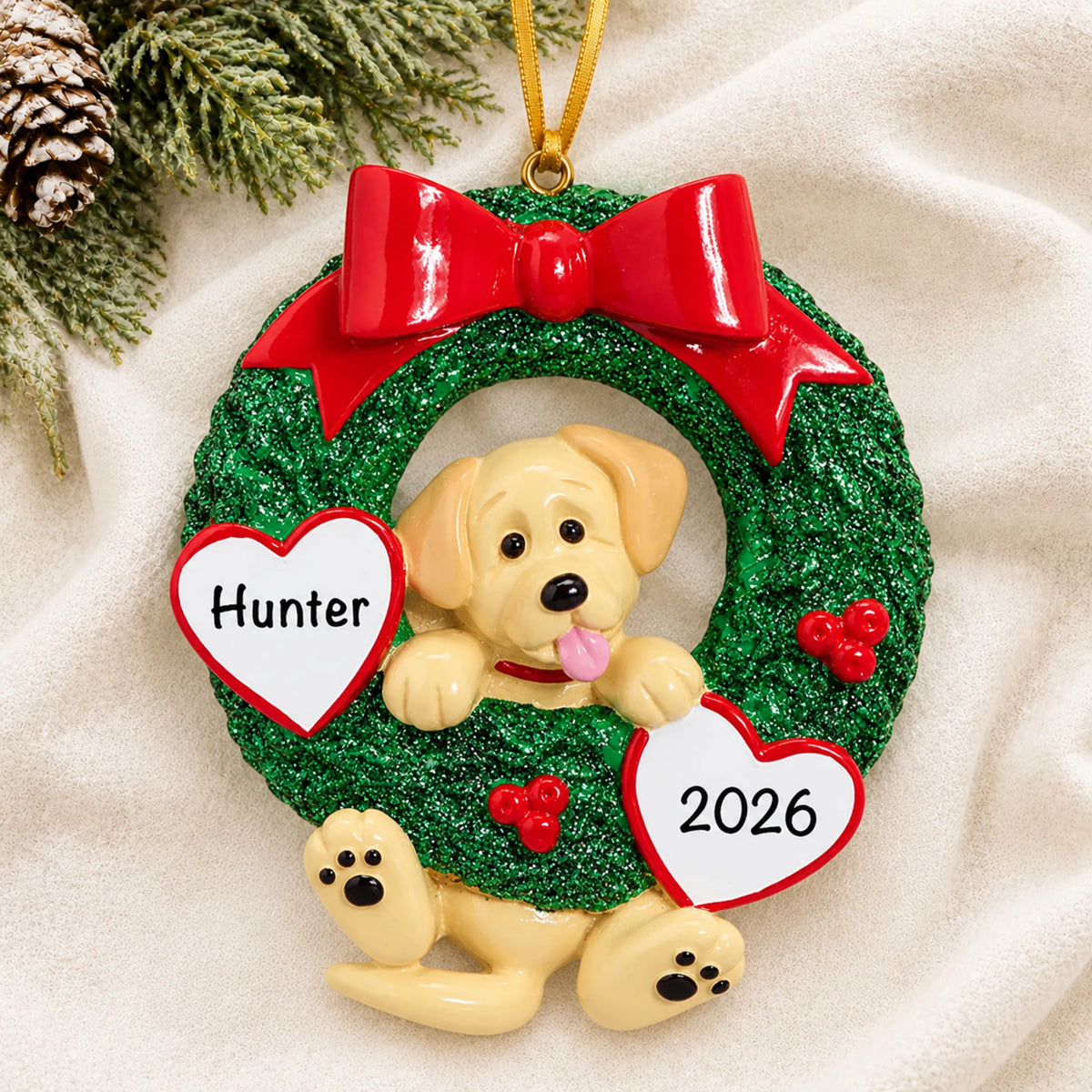 Personalized Yellow Lab Glitter Wreath christmas ornament laid on a soft white knit blanket