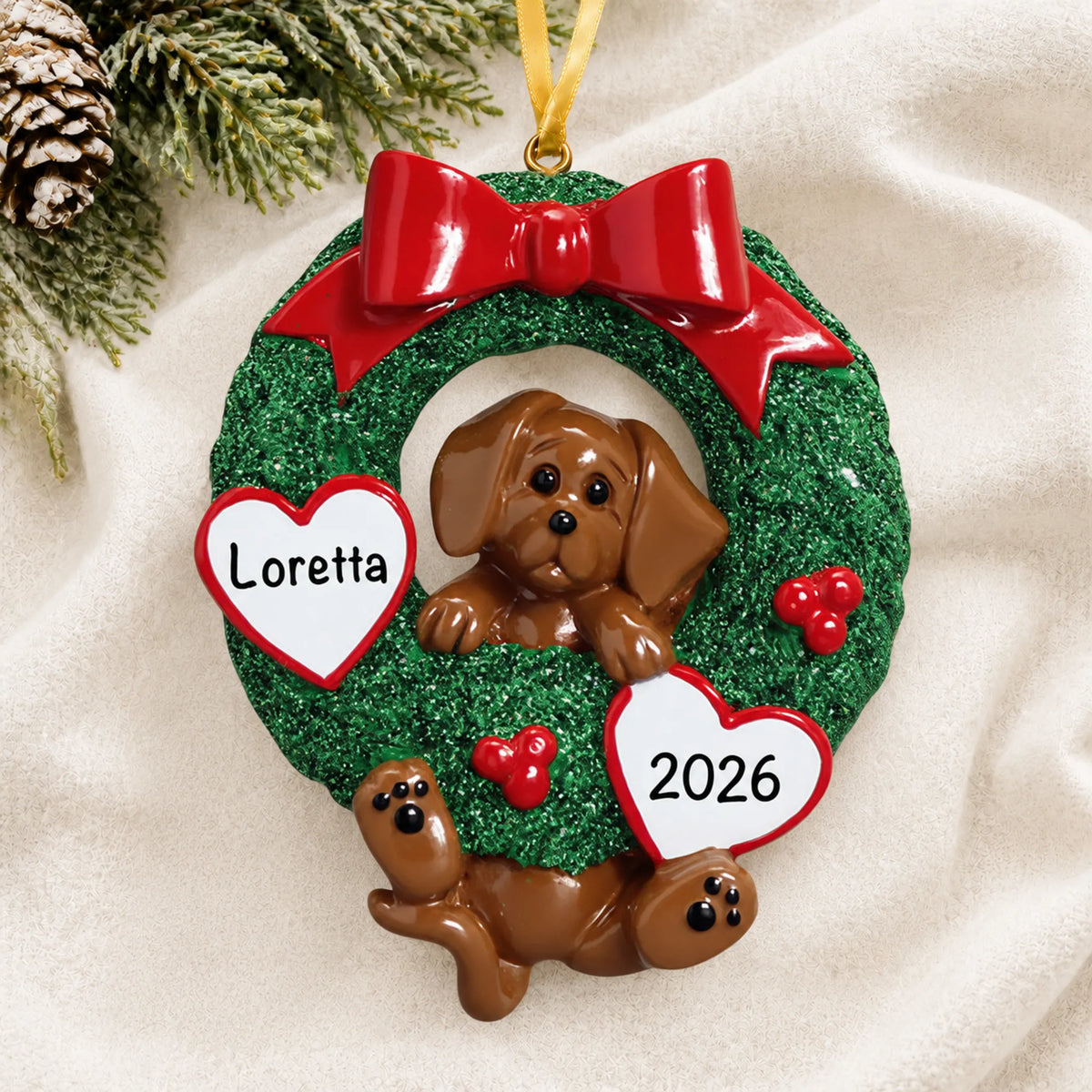 Personalized Dachshund Glitter Wreath christmas ornament laid on a soft white knit blanket
