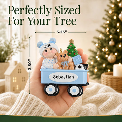 Size guide: the personalized blue wagon baby boy christmas ornament is 3.25 in wide by 3.50 in tall, shown in hand