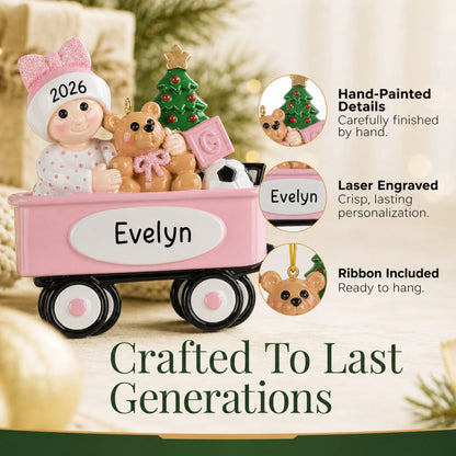 Hand-painted details and laser engraved personalization on the pink wagon baby girl christmas ornament, ribbon included