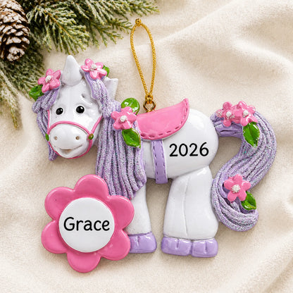 Personalized unicorn flower bloom christmas ornament laid on a soft white knit blanket