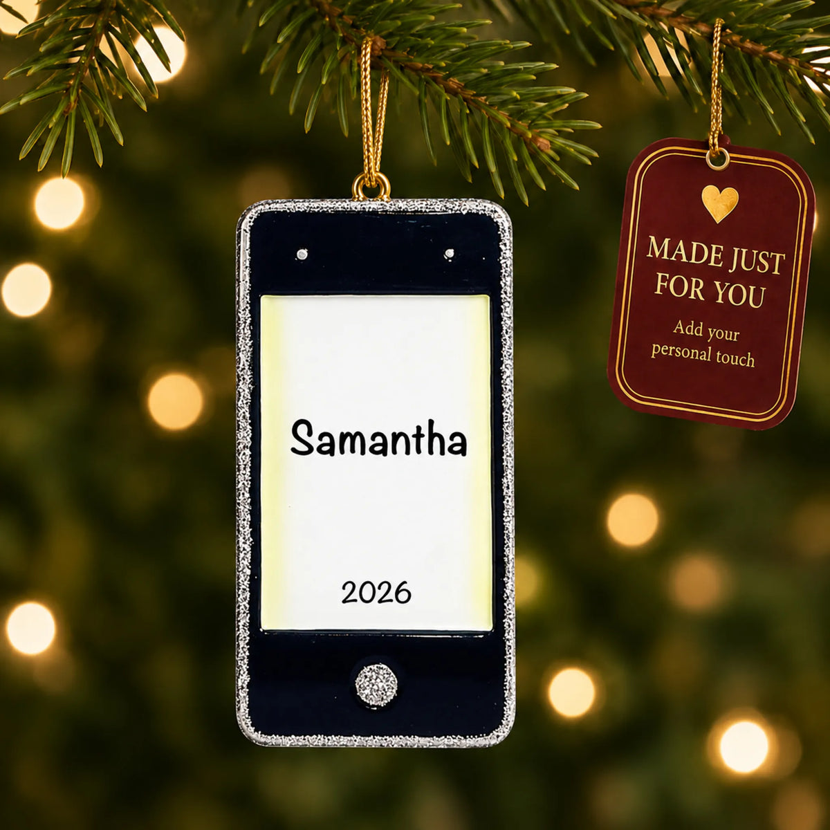 Cell phone christmas ornament hanging on a lit Christmas tree with a Made Just For You gift tag